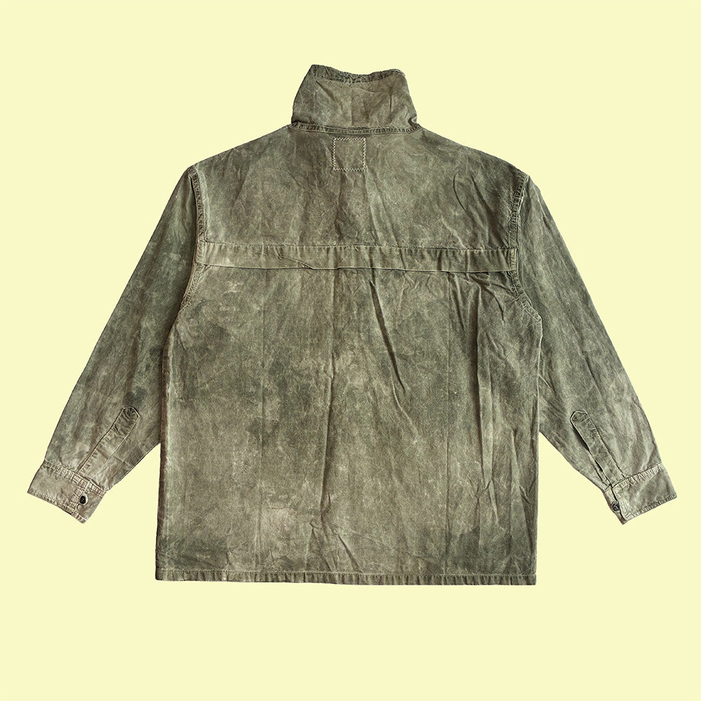 A long-sleeve high-collar utility smock in a washed, hand waxed olive green fabric.