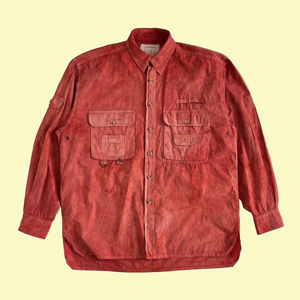 A hand dyed red long-sleeve button-up shirt jacket with two front chest pockets, laid flat against a pale yellow background. dyed with indian madder.